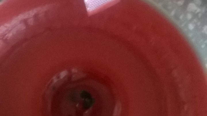 Ein rosa Dekoband h&auml;ngt &uuml;ber einem roten Kerzenboden in einem Glas, um das Ausfransen zu verhindern und ansprechend zu gestalten.