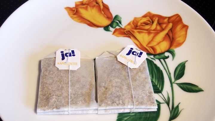 Zwei Teebeutel liegen auf einem blumenverzierten Teller, bereit, in hei&szlig;es Wasser gegeben zu werden.