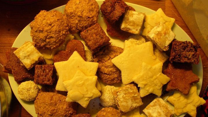 Ein bunter Teller mit verschiedenen Weihnachtspl&auml;tzchen, die auf einem Tisch zum Ausklang der Weihnachtszeit pr&auml;sentiert werden.