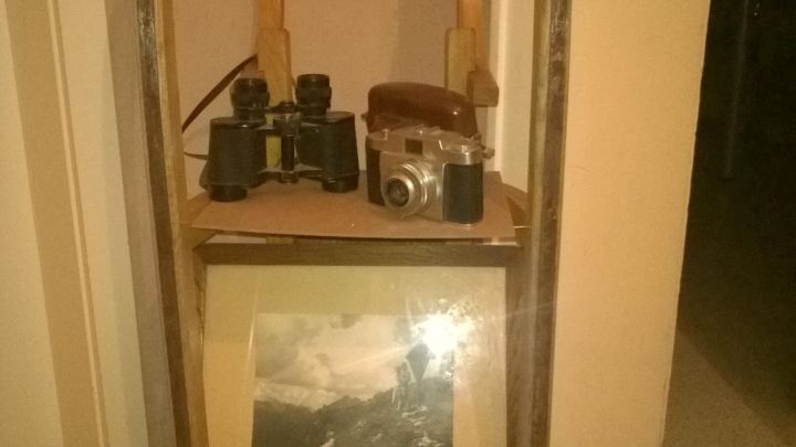 Ein Schlitten dient als Regal und tr&auml;gt Kameras und ein Bild in einem heimischen Raum.