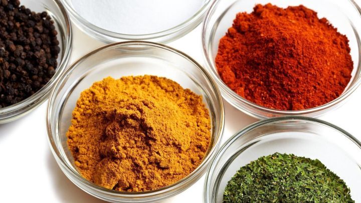 Kleine Gew&uuml;rzd&ouml;schen mit bunten Gew&uuml;rzen sind auf einem Tisch angeordnet, ideal f&uuml;r den Urlaub und zum Kochen.