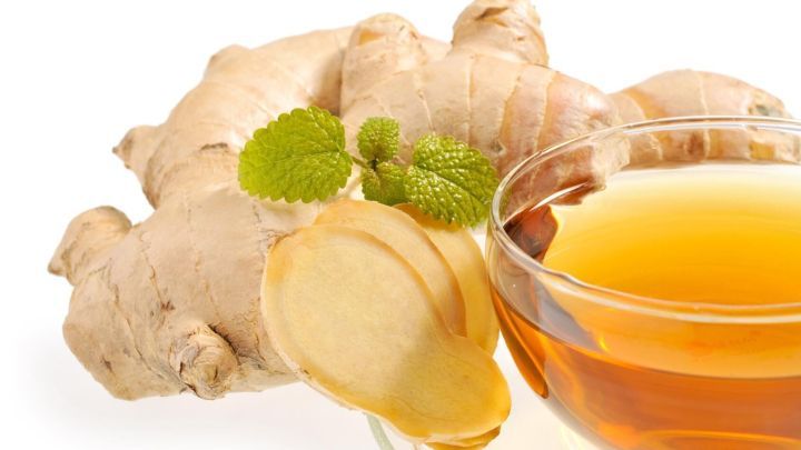 Frischer Ingwer liegt neben einer Schale mit dampfendem Tee, der in einer hellen, sauberen Umgebung pr&auml;sentiert wird.