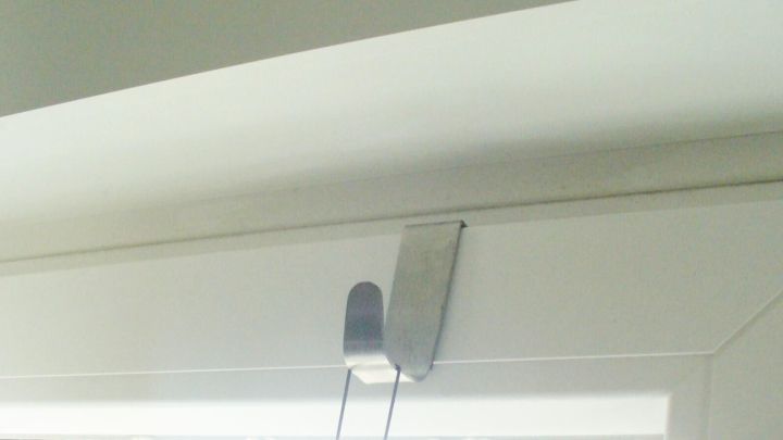 Ein Halter f&uuml;r eine Fensterdekoration ist am oberen Fensterrahmen montiert, ohne den Rahmen zu besch&auml;digen.