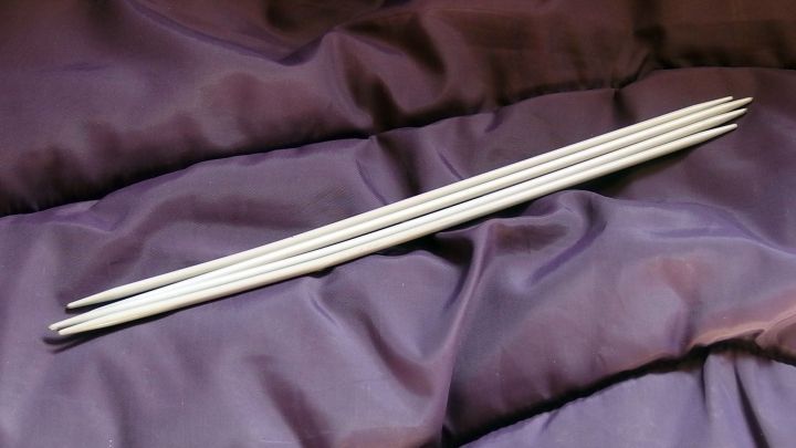 Stricknadeln liegen auf einem dunklen Stoff und sind bereit, im Flugzeug verwendet zu werden.