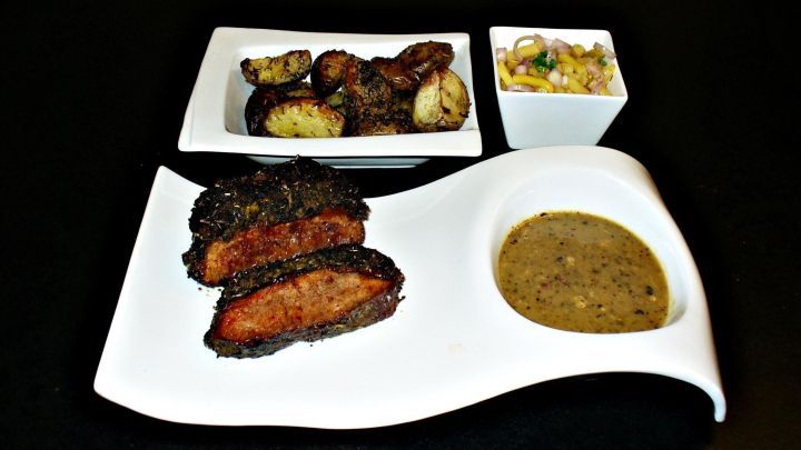 Zartes Roastbeef liegt auf einem eleganten Teller, begleitet von knusprigen Kartoffeln und einer w&uuml;rzigen So&szlig;e in stilvoller Anordnung.