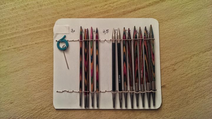 KnitPro Nadelspitzen stehen ordentlich in einer Halterung, mit einem Schl&uuml;ssel zum Einstellen griffbereit, auf einem Holzuntergrund.