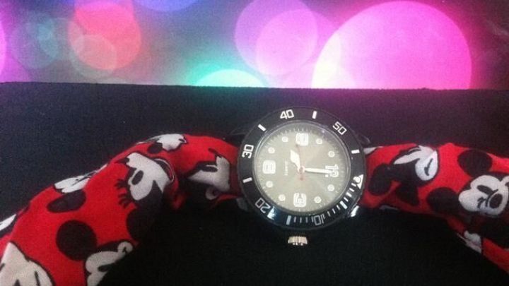 Eine stilvolle Armbanduhr mit einem roten Tuch im Hintergrund, das bunte Lichter reflektiert und eine lebendige Atmosph&auml;re schafft.