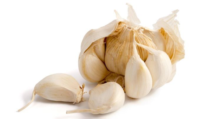 Knoblauchzehen liegen auf einer wei&szlig;en Fl&auml;che, bereit zum einfachen Sch&auml;len, um ihre Verwendung im Kochen zu erleichtern.