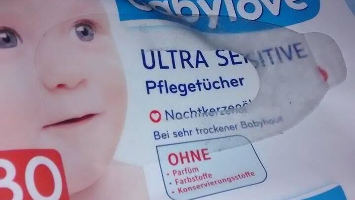 Die Packung mit babylove Ultra Sensitive Pfleget&uuml;chern sch&uuml;tzt gereizte Haut. Sie liegt auf einem weichen Untergrund.