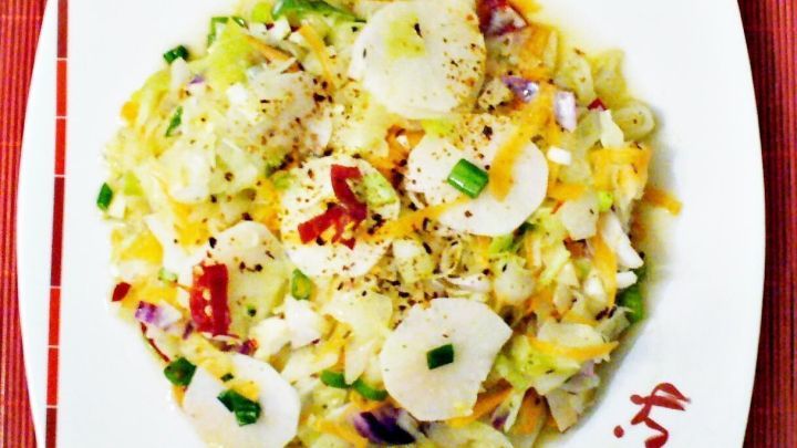 Ein flacher Teller zeigt eine bunte Mischung aus Wei&szlig;kohl, Gem&uuml;se und Gew&uuml;rzen, die als europ&auml;isches Kimchi serviert wird.