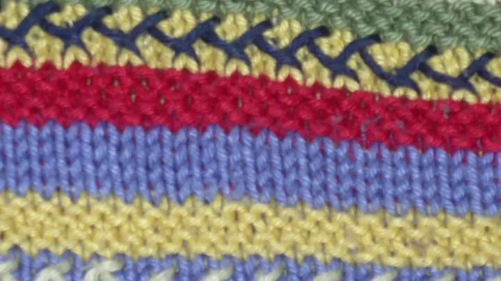 Vorderseite: Grundlage ist ein schmaler glatt rechts gestrickter Streifen (4 Reihen): Hexenstich oder Kreuzstich