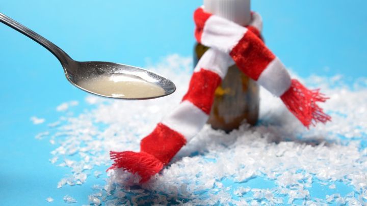 Ein Fl&auml;schchen mit &Ouml;l steht auf einer wei&szlig;en, kristallinen Fl&auml;che, w&auml;hrend ein L&ouml;ffel die Fl&uuml;ssigkeit zum Mund f&uuml;hrt.