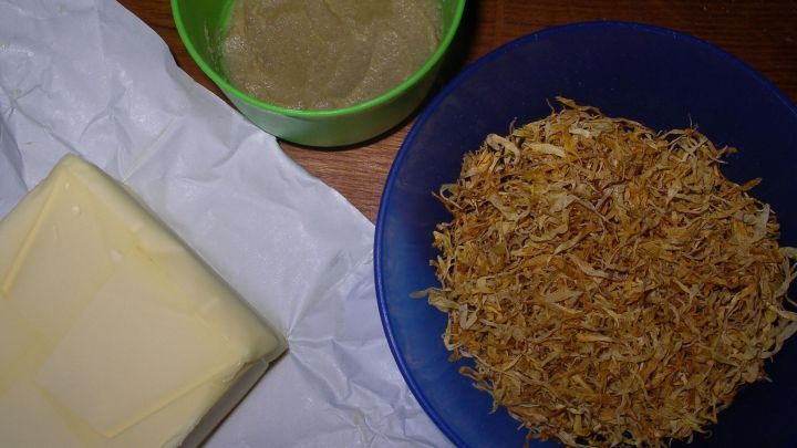 Eine gelbe Butterblock liegt neben einer Sch&uuml;ssel mit Kr&auml;utermischung und einer weiteren Sch&uuml;ssel mit einer Paste.