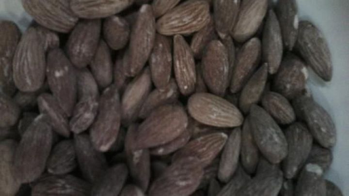 Gesalzene Mandeln sind in einer Sch&uuml;ssel angeordnet, die Mandeln leuchten leicht salzig und knusprig, perfekt zum Snacken.