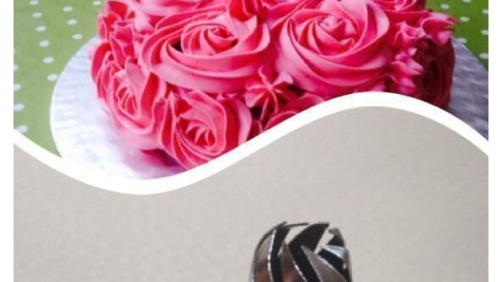 Ein Kuchen mit pinken Rosen aus Frosting steht auf einem gr&uuml;nen, gepunkteten Tischtuch; darunter eine Spritzt&uuml;lle.