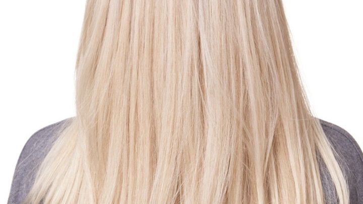 Langes, kr&auml;ftiges Haar liegt glatt auf den Schultern einer Person und strahlt Gesundheit aus, vor einem neutralen Hintergrund.