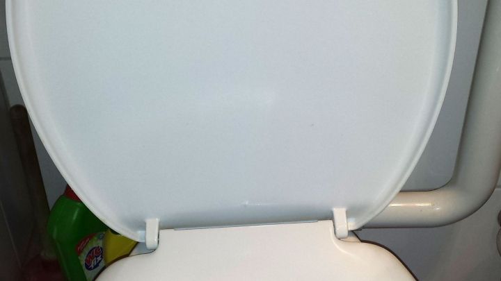 Toilettensitz offen; Putzmittel flaschen hinter WC; Kontext: Badezimmer mit schwer zug&auml;nglichem Reinigungsbereich.