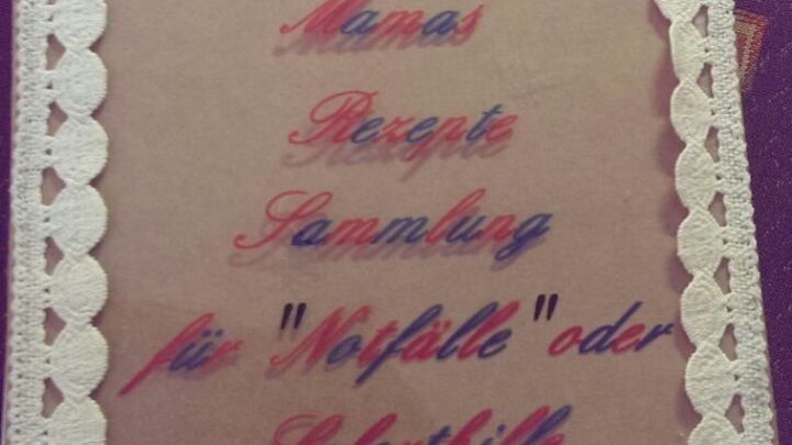 Ein handgemachtes Kochbuch liegt offen auf einem Tisch. Es zeigt eine dekorative Sammelmappe f&uuml;r Rezepte oder Tipps.