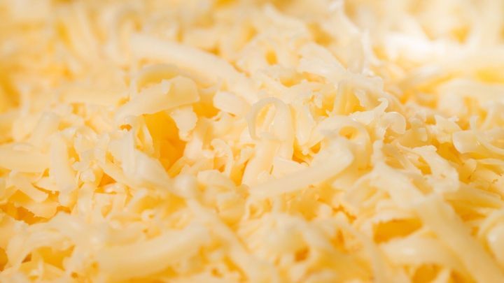 Geriebener Analogk&auml;se liegt in Haufen, nah aufgenommen, um die Oberfl&auml;che und Textur im Detail zu zeigen.