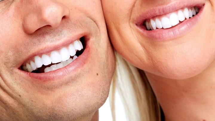 Zwei l&auml;chelnde Gesichter zeigen ihre wei&szlig;en Z&auml;hne, eng aneinander geschmiegt, in einem fr&ouml;hlichen Moment.