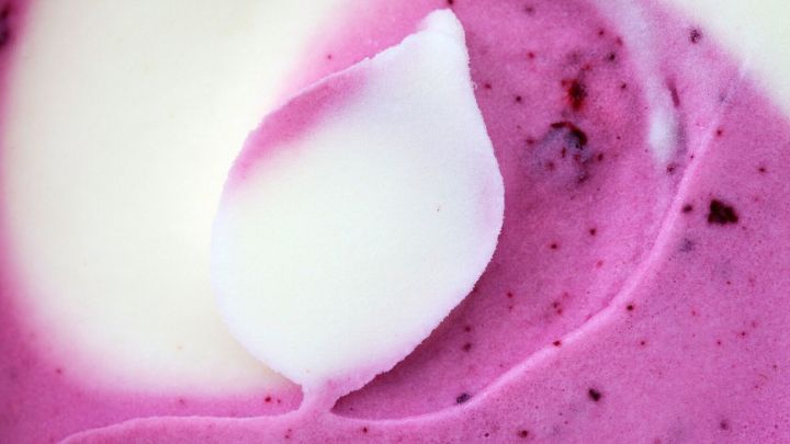 Eine cremige Joghurteis-Mischung mit lila und wei&szlig;er Farbe liegt in einem Beh&auml;lter, bereit zum Genie&szlig;en.