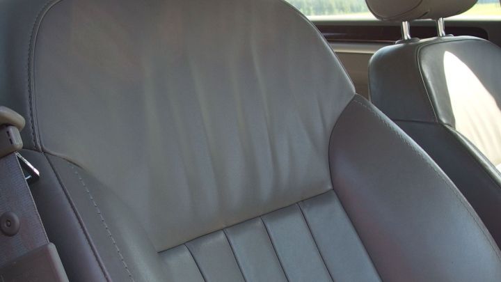 Ein Ledersitz ist zu sehen, der mit Melkfett bearbeitet wird, um ihn weicher und geschmeidiger zu machen.