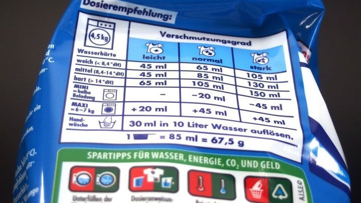 Eine Waschmittelverpackung zeigt die Dosierungshinweise f&uuml;r verschiedene Wasserh&auml;rten, um richtige Dosierung zu gew&auml;hrleisten.