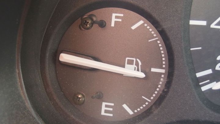 Ein Kraftstoffstandsanzeiger zeigt den F&uuml;llstand, w&auml;hrend ein Fahrzeug spritsparend f&auml;hrt und auf effiziente Nutzung pr&uuml;ft.