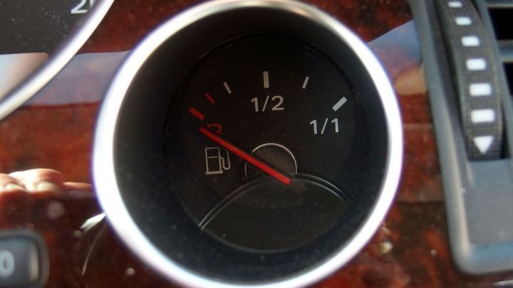 Ein Kraftstoffanzeiger zeigt etwa die H&auml;lfte des Tankinhalts an, w&auml;hrend das Auto in einem Fahrzeuginterieur steht.