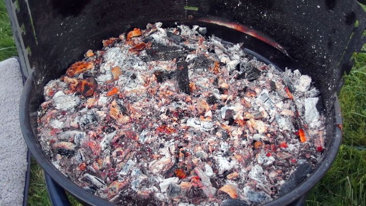 Ein Holzkohlegrill mit gl&uuml;hender Kohle, der bereit ist, f&uuml;r ein Grillfest im Freien genutzt zu werden.