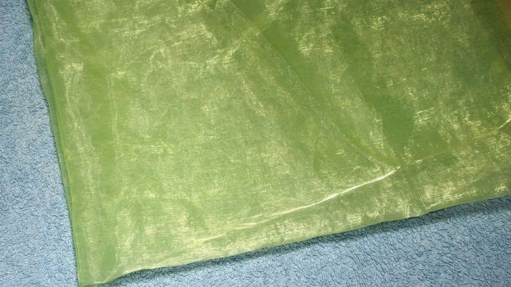 Ein gr&uuml;nes Fliegengitter liegt auf einem blauen Untergrund, um Insekten vom K&uuml;hler fernzuhalten.