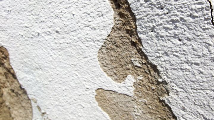 Eine br&ouml;selige Wand zeigt Stellen mit abbl&auml;tterndem Putz, was eine Herausforderung beim Befestigen von Schrauben darstellt.