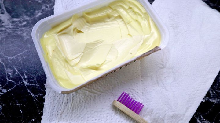 Eine Packung Margarine liegt auf einem Tuch, neben einer Zahnb&uuml;rste, bereit zum Reinigen von Felgen.