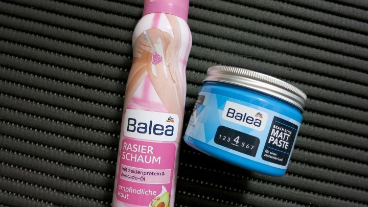 Ein Haargel und Rasierschaum stehen auf einer schwarzen Matte, bereit zur Anwendung gegen Haarprodukte.