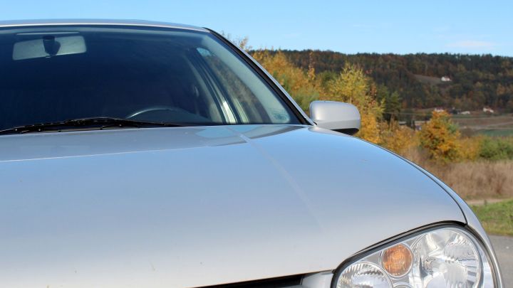 Ein silbernes Auto steht in einer klaren Umgebung, das Petroleum-Wassergemisch wird zur Reinigung seiner Oberfl&auml;che verwendet.