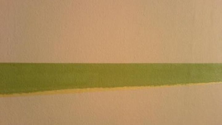 Eine gr&uuml;ne Farbkante verl&auml;uft sauber und exakt entlang der Wand, um pr&auml;zise Malerarbeiten zu erm&ouml;glichen.