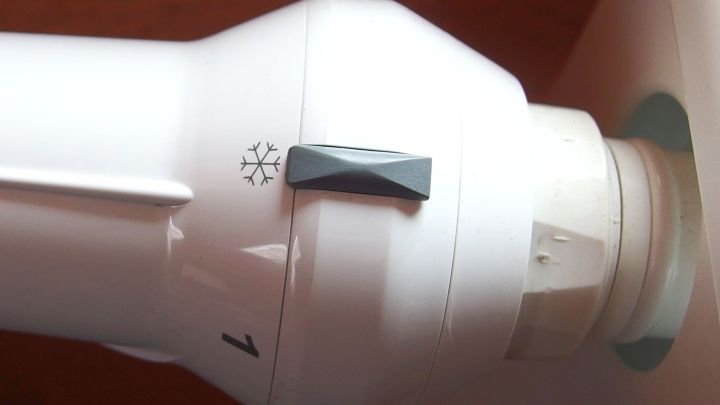 Ein Heizungs-Thermostat mit Frostschutzfunktion zeigt den Einstellbereich an und ist an einem Wandheizk&ouml;rper montiert.