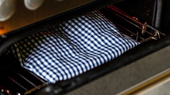 Ein kariertes Tuch liegt in einem Ofen. Der Ofen ist in benutztem Zustand, um das Tuch schnell zu trocknen.