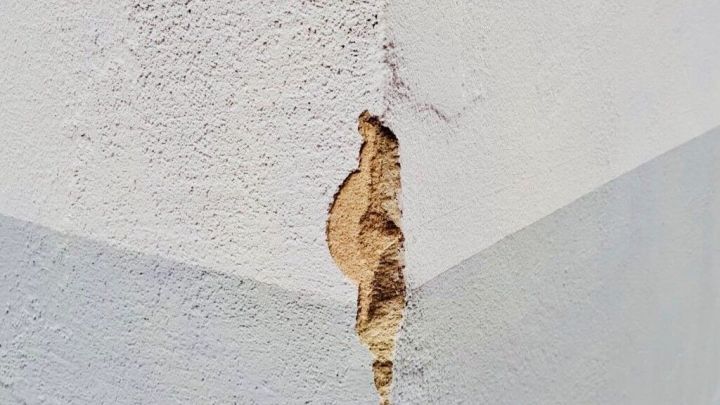 Eine besch&auml;digte Mauerfuge zeigt Risse an der Ecke eines Geb&auml;udes, die flott ausgef&uuml;llt werden m&uuml;ssen.