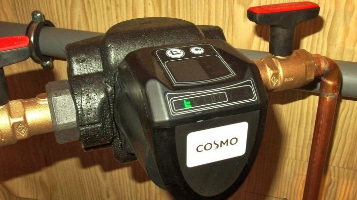 Eine Zirkulationspumpe steuert den Wasserfluss in einem Heizsystem. Sie ist in einem Technikraum installiert.