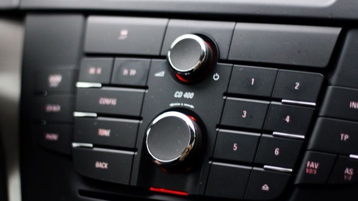 Ein gl&auml;nzendes Armaturenbrett mit Reglern und Kn&ouml;pfen, die f&uuml;r Musik und Einstellungen im Fahrzeug verwendet werden.