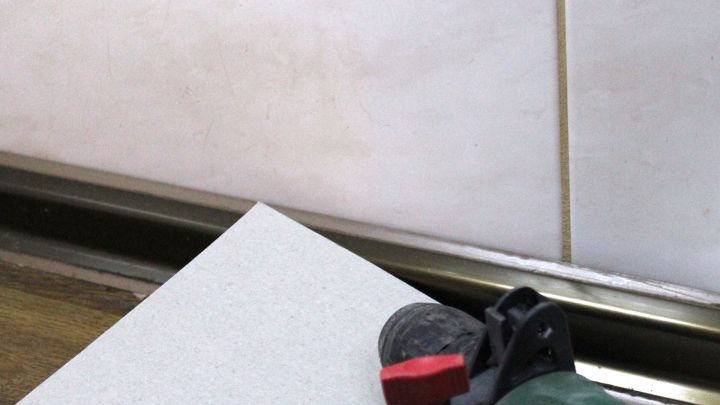 Ein Bohrger&auml;t liegt auf einer Fliese und ist bereit, ein Loch zu bohren, um in einem fliesenartigen Umfeld zu arbeiten.