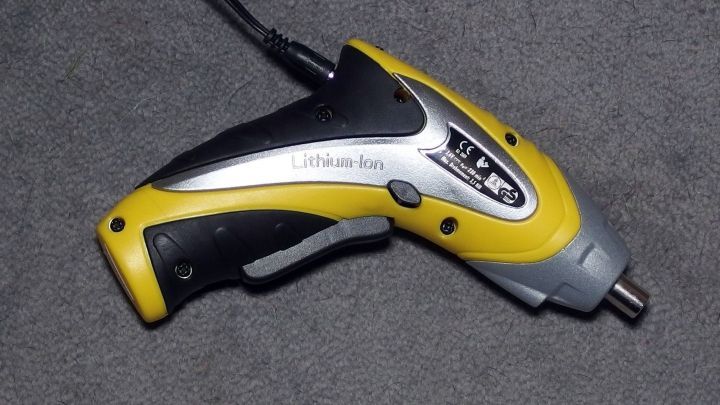 Ein Akku-Schrauber liegt auf einem grauen Untergrund, bereit zum Schrauben mit neuem Akku f&uuml;r effizientere Anwendungen.