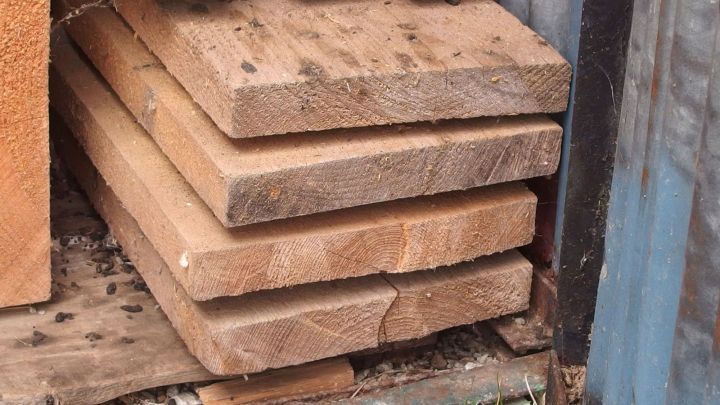 Gestapelte Bretter liegen ordentlich auf einem Holzuntergrund, bereit zum Schneiden in gleichlange St&uuml;cke.