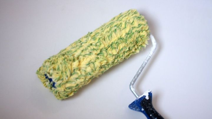 Ein Farbroller liegt auf einem wei&szlig;en Hintergrund. Er sieht schmutzig aus und k&ouml;nnte in der Waschmaschine ausgewaschen werden.