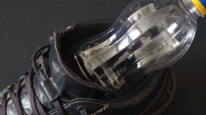 Eine PET-Flasche steckt als Schuhspanner in einem schwarzen Schuh, um die Form des Schuhs zu erhalten.