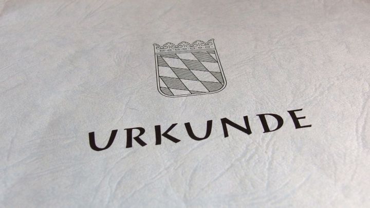 Eine Urkunde mit einer Wappenzeichnung, die den Erwerb einer denkmalgesch&uuml;tzten Wohnung dokumentiert.