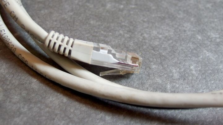 Ein Netzwerk- und ein Verl&auml;ngerungskabel liegen ordentlich auf einer grauen Oberfl&auml;che, bereit f&uuml;r den Einsatz ohne Kabelsalat.