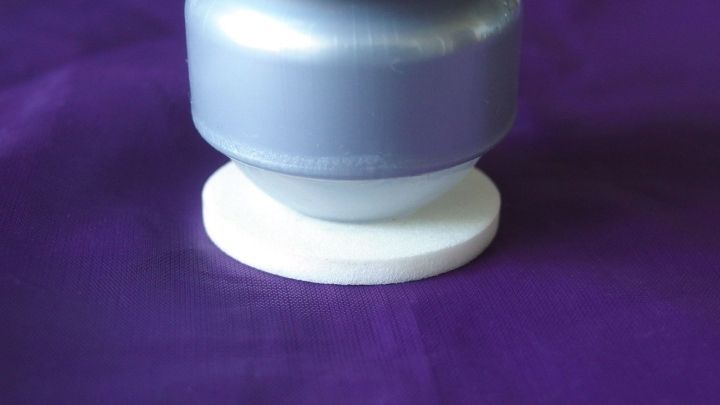 Ein Deo-Roller steht auf einem wei&szlig;en Untersetzer auf einem lila Hintergrund, bereit zur Nutzung im Alltag.