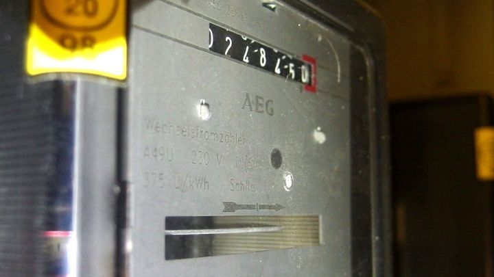 Ein Stromz&auml;hler zeigt digitale Werte an, w&auml;hrend er in einem technischen Raum installiert ist.